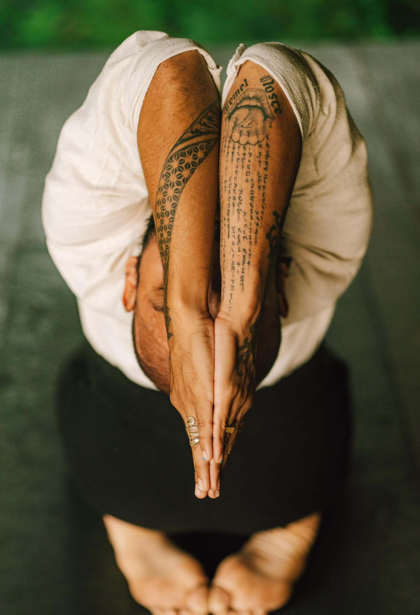 Kneeling Yoga Pose with Prayer Hands – Free Lopez in Tropical Garden Top view of Free Lopez kneeling in a yoga pose with head lifted toward the sky, hands in prayer position in front of his face, set in a serene tropical garden, expressing devotion, grounding, and mindfulness.