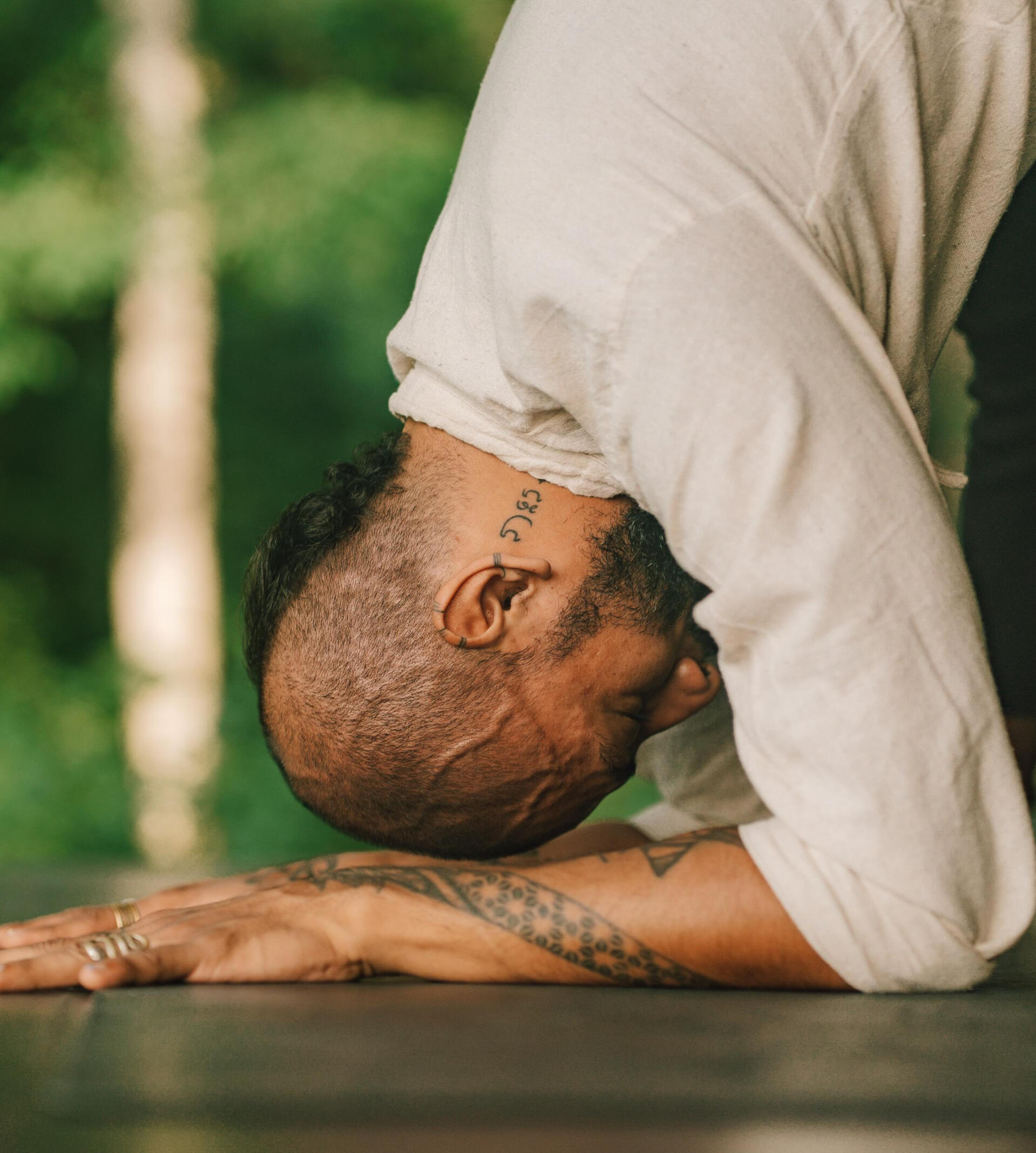 Free Lopez performing a yoga inversion asana Free Lopez practicing a yoga forearm stand with head lifted, arms and shoulders engaged, in a lush tropical garden setting in Ashtari Lombok, showcasing strength, balance, and focus
